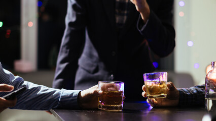 A group of businessmen held brandy glasses together to cheers glasses of brandy after concluding...