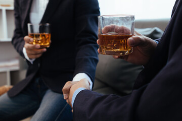 Businessmen and investors drink alcohol together in office after discussing their joint venture...