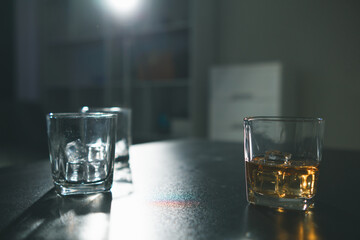 brandy glass that is kept on table in office is a glass of brandy that business people often drink after working hours to let the alcohol help them relax. Concept of relaxing with alcoholic beverages