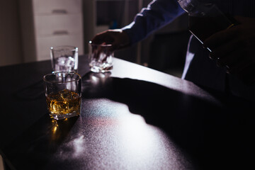 brandy glass that is kept on table in office is a glass of brandy that business people often drink after working hours to let the alcohol help them relax. Concept of relaxing with alcoholic beverages