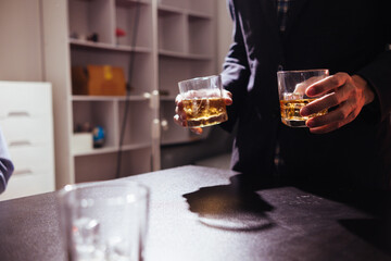 Businessmen and investors drink alcohol together in office after discussing their joint venture plans to conclusion. backdrop of alcoholic celebrations between investors and successful businessmen.