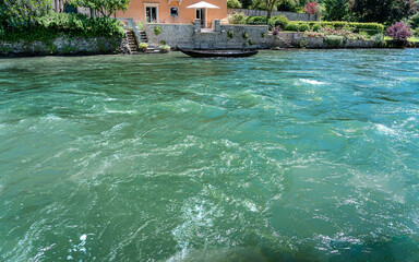 in the foreground the beautiful blue and emerald-green rough waters of a river with a...