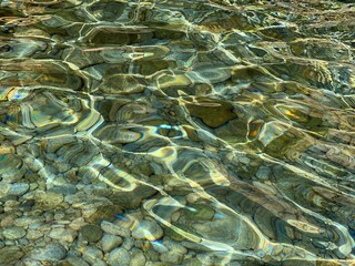 Sea transparent water with smooth pebbles stones