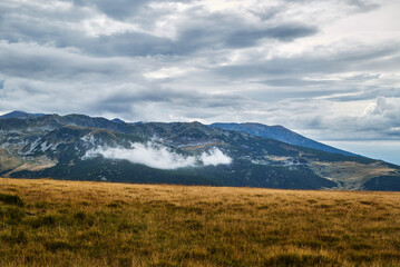 The sky is dark with very black clouds over the field on the Transalpina. Dramatic sky ready for the storm