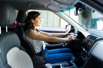 Naklejka premium Focused woman driving her car attentively, illustrating safe and independent urban driving from a side view perspective