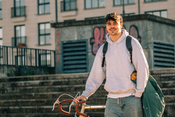 young man or student on the street with vintage bicycle at sunset © carballo