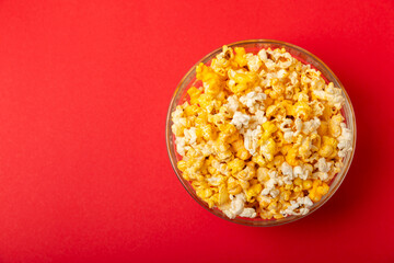 Popcorn box. Red and white striped buckets of popcorn on a red background. Cinema and entertainment concept. Movie night with popcorn. Cheesy popcorn. Delicious appetizer, snack. Place for text.