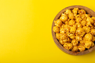 Delicious popcorn in a bowl on a yellow background. Cinema and entertainment concept. Movie night with popcorn.Cheese and caramel popcorn. Delicious appetizer, snack. Place for text. Copy space.Banner