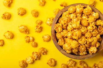 Delicious popcorn in a bowl on a yellow background. Cinema and entertainment concept. Movie night with popcorn.Cheese and caramel popcorn. Delicious appetizer, snack. Place for text. Copy space.Banner