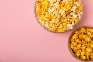 Delicious popcorn in a bowl on a pink background. Cinema and entertainment concept. Movie night with popcorn. Cheese and caramel popcorn. Delicious appetizer, snack. Place for text. Copy space.Banner