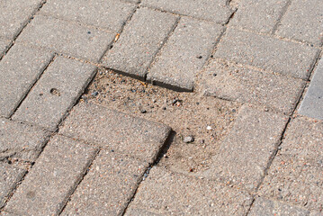 Sidewalk with pothole. Defects on paving slabs, improperly laid paving stones. Inferior or...