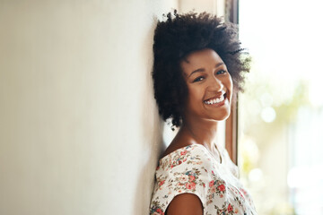 Portrait, happy woman and relax by wall in home, holiday and morning with wellness. African girl,...