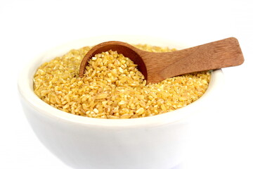 Raw Bulgur in a bowl Isolated on a white background. Raw bulghur, dry cracked parboiled wheat groats, cereal 