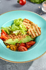 Grilled chicken fillet and avocado salad bowl with fresh veggies on a sun-kissed tabletop