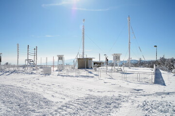 An ice-covered screen weather station, high on a mountain