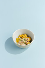 Delicious Meat Ravioli with Mushroom Sauce in a Stylish Bowl on a Light Blue Background