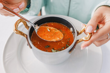 Close-up of a spoon dipping into a bowl of delicious fish stew, showcasing the mouthwatering flavors of this traditional dish.