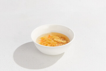 Delicious Chicken Noodle Soup in White Bowl - Classic Comfort Food on White Background