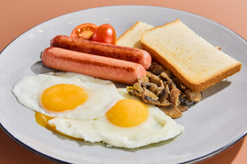 Delicious Breakfast Plate with Fried Eggs, Sausages, Mushrooms, and Toast