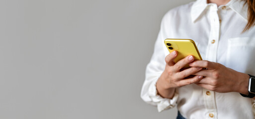 Searching job. Female business person wearing white shirt messaging online using her smartphone.