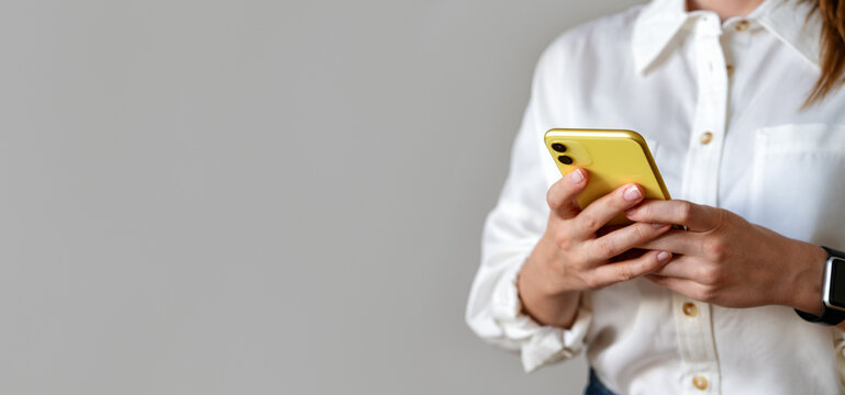 Searching job. Female business person wearing white shirt messaging online using her smartphone.