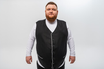 Hey you! Portrait of a happy, emotional bearded man in a light t-shirt and a black vest on a light background. Studio shot.
