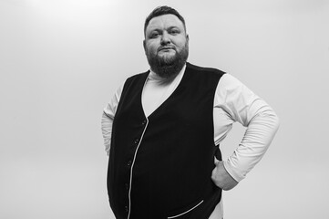 black and white emotional portrait of a bearded man in a white t-shirt and vest on a light background, had lunch, emotions, place for inscription