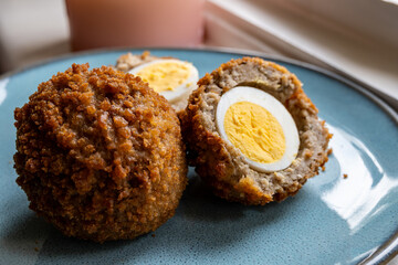 Traditional street food in UK, stuffed fried Scotch eggs with breadcrumbs close up