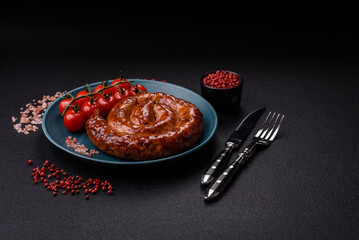 Delicious homemade sausage in the form of a spiral baked on the grill with salt, spices