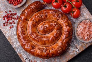 Fototapeta premium Delicious homemade sausage in the form of a spiral baked on the grill with salt, spices