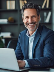 Fototapeta premium Happy smiling middle aged professional business man company executive ceo manager wearing blue suit sitting at desk in office working on laptop computer. Portrait. Generative AI. hyper realistic 