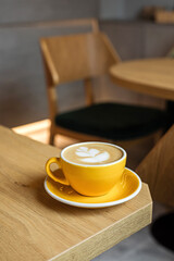 A yellow cup of cappuccino coffee