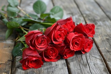 Multiple red roses displayed on a wooden platform
