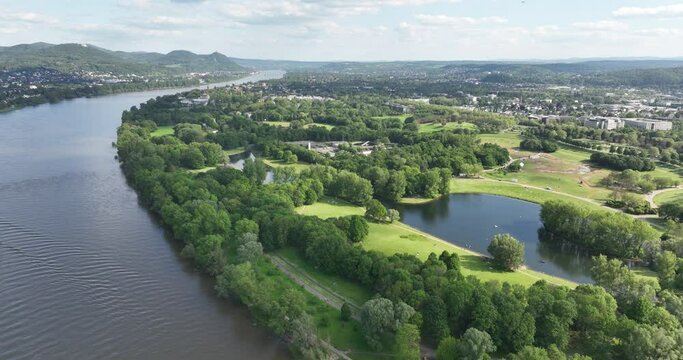 Aerial drone view of the city of Bonn, Germany looking over the Freizeitpark Rheinaue along the rhine river in summer time.