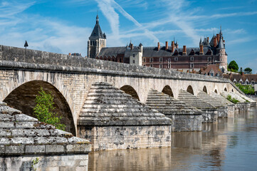 View.on old part of town of Gien on the Loire river, in Loiret department, France, houses with tiled roofs and chimneys, castle and bridge