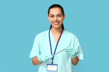 Portrait of female doctor with tongue depressor on blue background