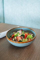 Fresh salad of strawberry cucumber lettuce and onion on a table at a restaurant vertical image