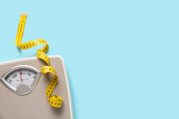 Scales with yellow measuring tape on blue background
