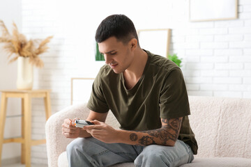 Diabetic young man using glucometer at home