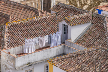 Clothes drying on rooftop terrace with traditional tiled roofs