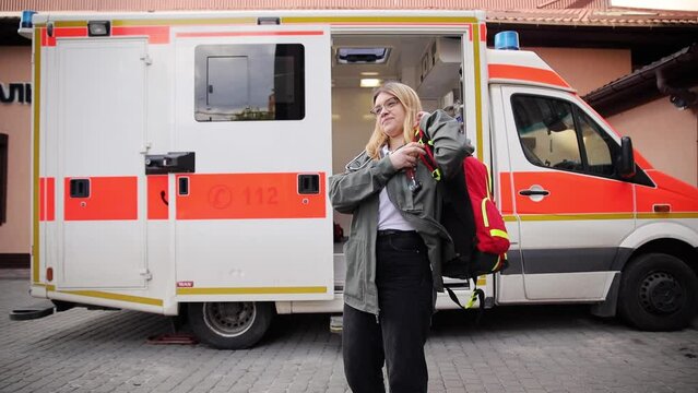 Portrait of a female EMS paramedic proudly standing in front of the camera in uniform. Successful emergency medical technician or doctor at work, rescue team staff
