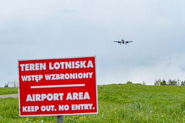 Plane Landing with Warning Sign in Foreground   Lądowanie samolotu ze znakiem ostrzegawczym na pierwszym planie © Adrian White