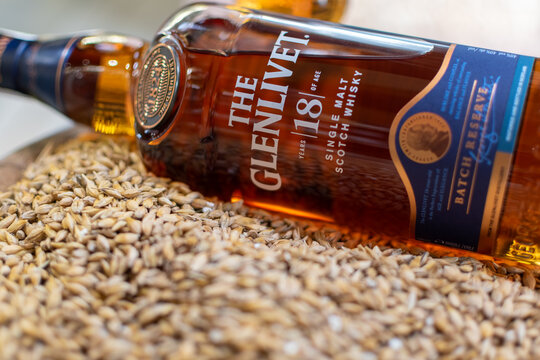 Bottle of single malt scotch whisky The Glenlivet Batch Reserve 18 years aged close-up on background of whisky glass on barley grains. Ukraine, Zhytomyr, June, 03, 2024