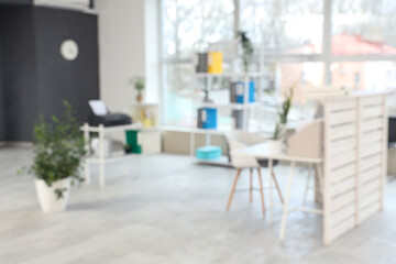 Blurred view of clinic with reception desk and shelf units