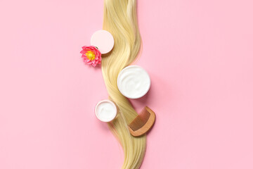 Blonde strand with jars of hair mask, comb and flower on pink background