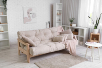 Beautiful interior of living room with cozy sofa, shelving units and coffee table, blurred view
