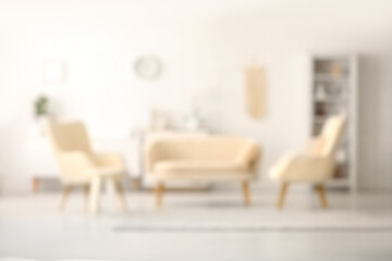 Blurred interior of living room with sofa and armchairs