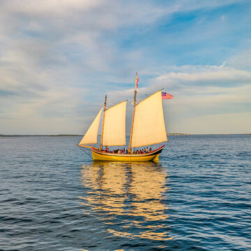 Sailboat on the bay in New England with sunset glow. 