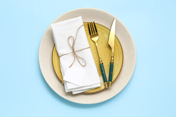 Beautiful table setting with golden cutlery on blue background