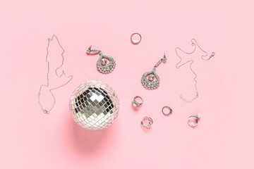 Beautiful jewelry and disco ball on pink background